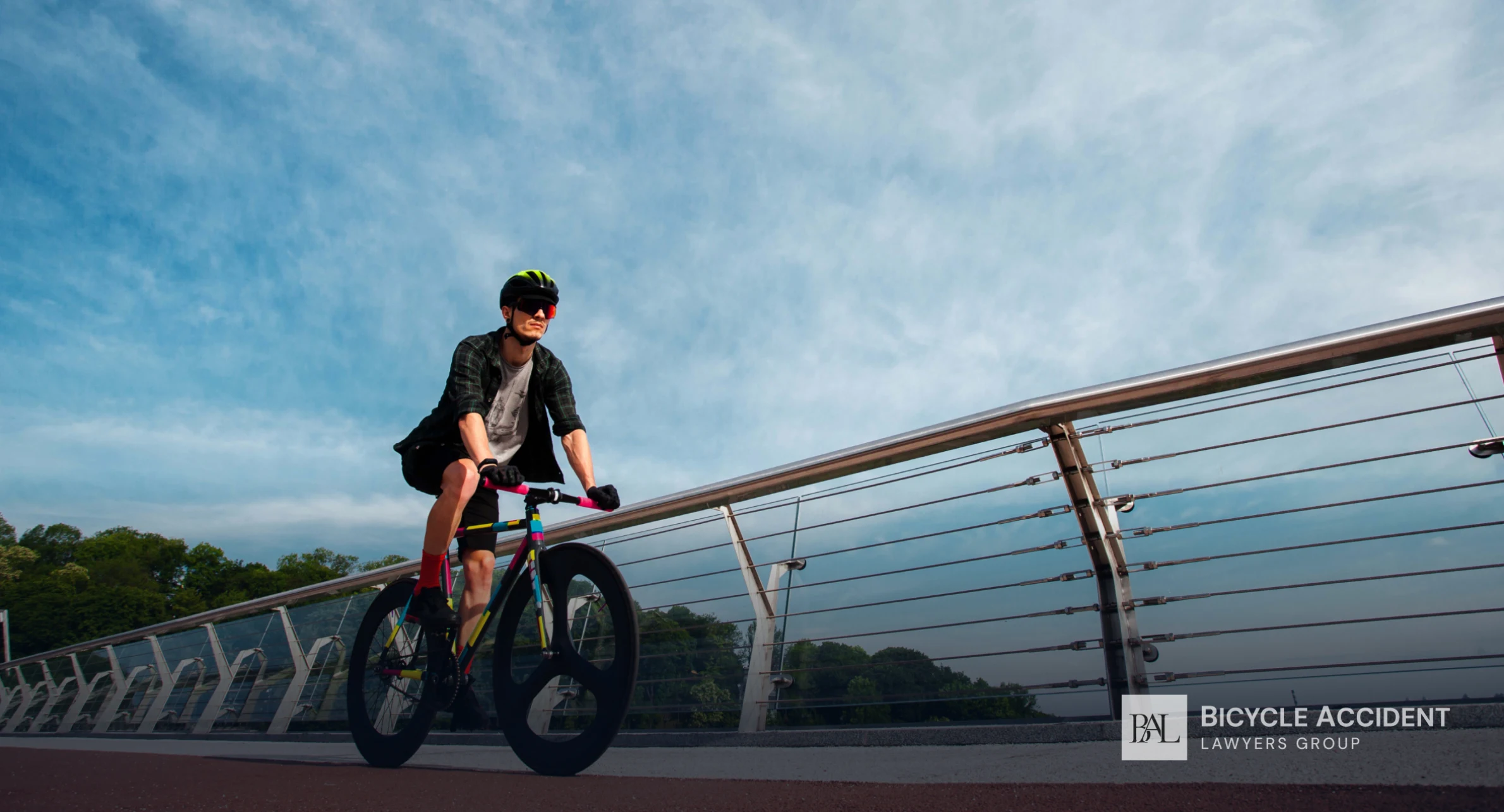 Cyclist riding across a modern bridge under a clear sky