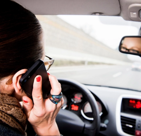 Driver talking on a phone while driving.