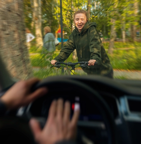 Cyclist in front of a car.